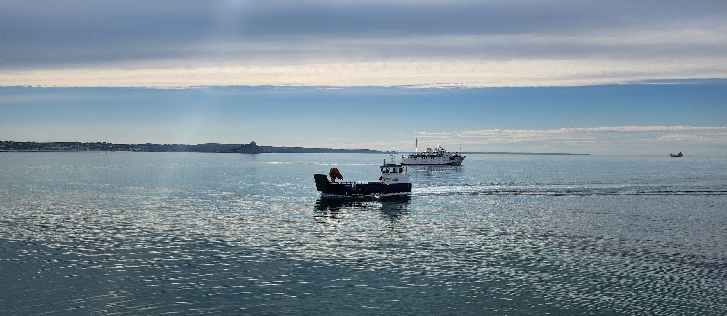 Gugh and Scillonian III sailing past each other in Penzance by St Michaels Mount