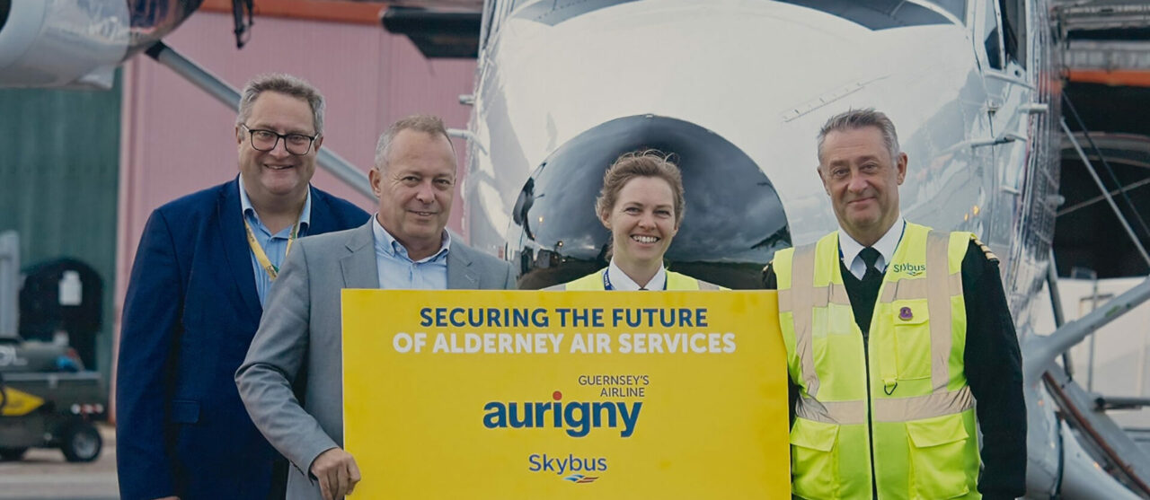 Skybus and auringy team members in front of a twin otter aircraft