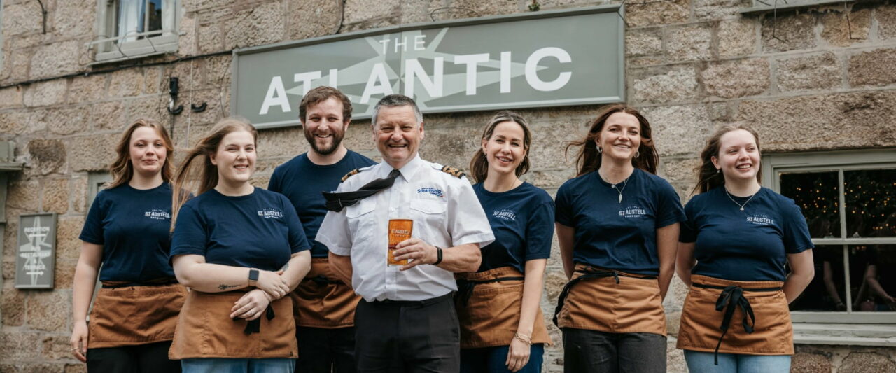 Dave Redgrave Scillonian III captain holding a pint of Scillonian Salute in front of The Atlantic Inn, St Austell Brewery - St mary's
